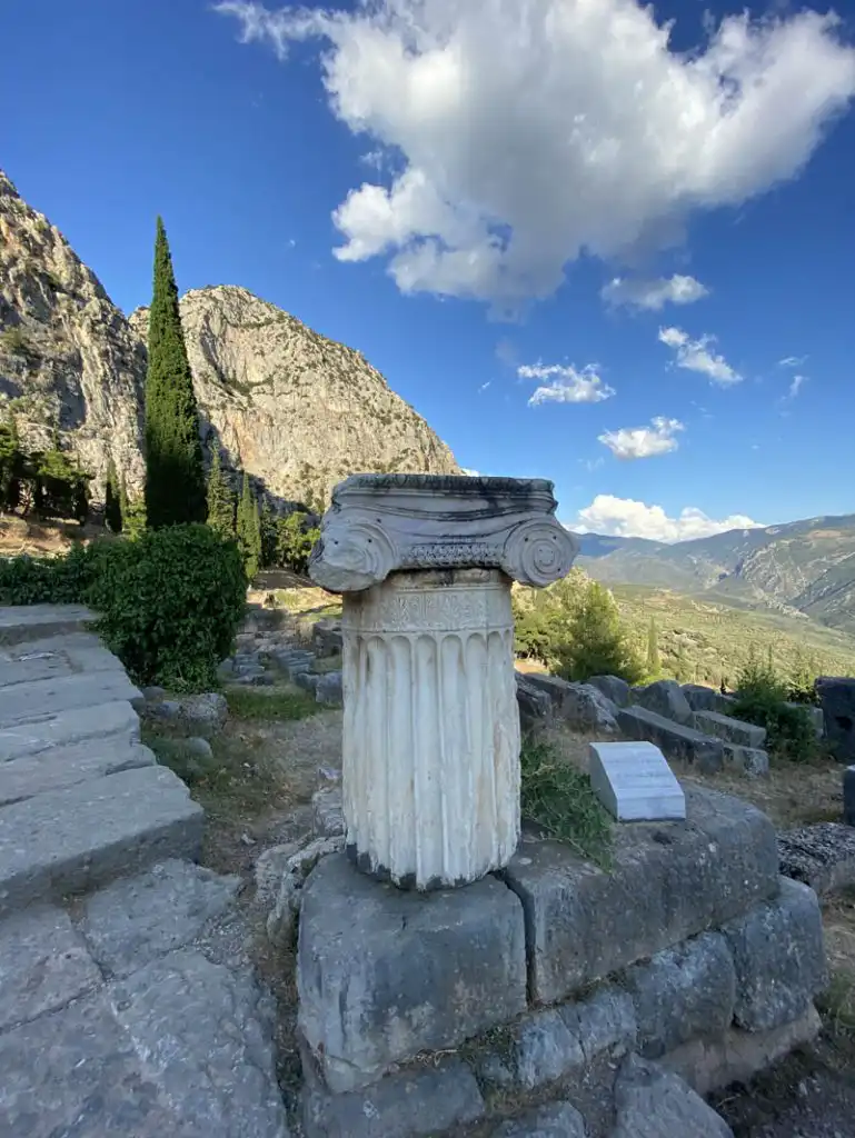 Αρχαίος ελληνικός κίονας με φόντο το ορεινό τοπίο των Δελφών.